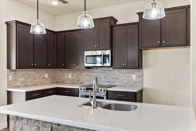 kitchen featuring backsplash, pendant lighting, and stainless steel appliances