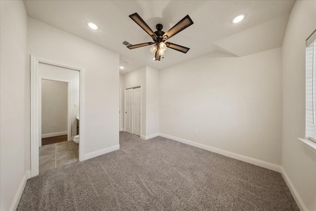 unfurnished bedroom with ceiling fan, light colored carpet, and a closet