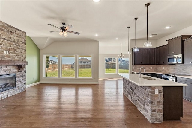 kitchen featuring appliances with stainless steel finishes, decorative light fixtures, decorative backsplash, sink, and dark brown cabinets