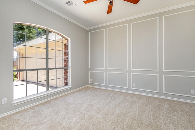 carpeted spare room with ornamental molding, ceiling fan, and a healthy amount of sunlight