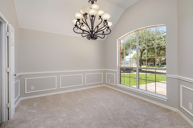 carpeted empty room with a healthy amount of sunlight, lofted ceiling, and a notable chandelier