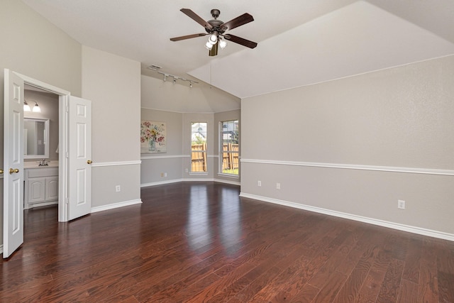 unfurnished room featuring dark hardwood / wood-style flooring, track lighting, vaulted ceiling, ceiling fan, and sink