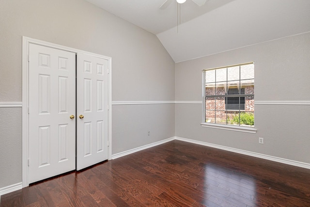 unfurnished bedroom featuring a closet, vaulted ceiling, ceiling fan, and dark wood-type flooring