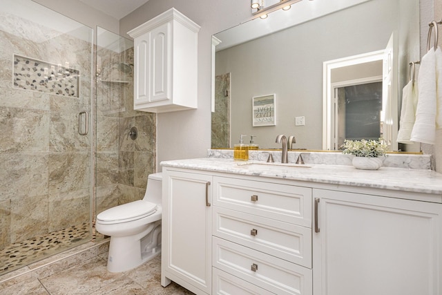 bathroom featuring vanity, toilet, and a shower with door