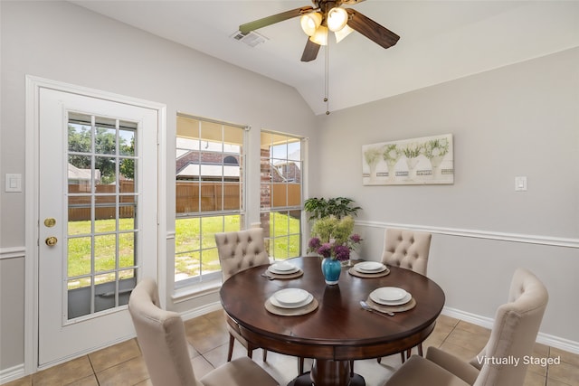 tiled dining area with ceiling fan and lofted ceiling