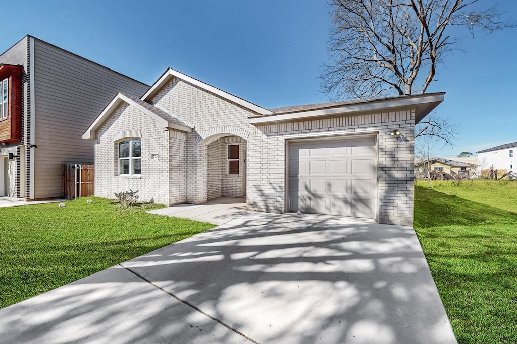 view of front of property featuring a garage and a front lawn