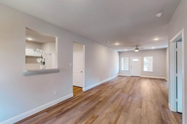 unfurnished living room with ceiling fan and light hardwood / wood-style flooring