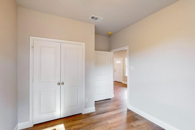 unfurnished bedroom with light hardwood / wood-style floors and a closet