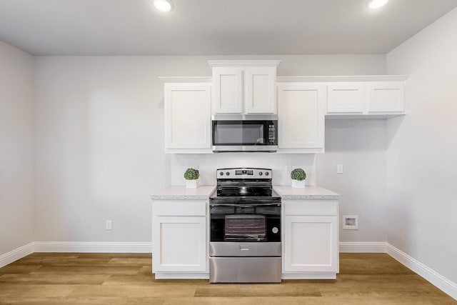 kitchen featuring decorative backsplash, white cabinets, and appliances with stainless steel finishes