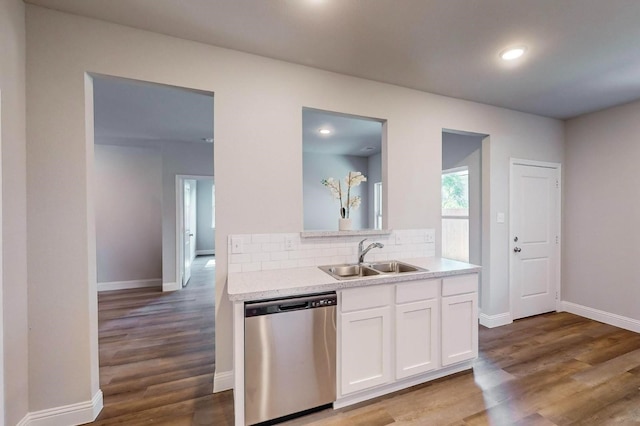 kitchen featuring tasteful backsplash, white cabinetry, sink, hardwood / wood-style flooring, and stainless steel dishwasher