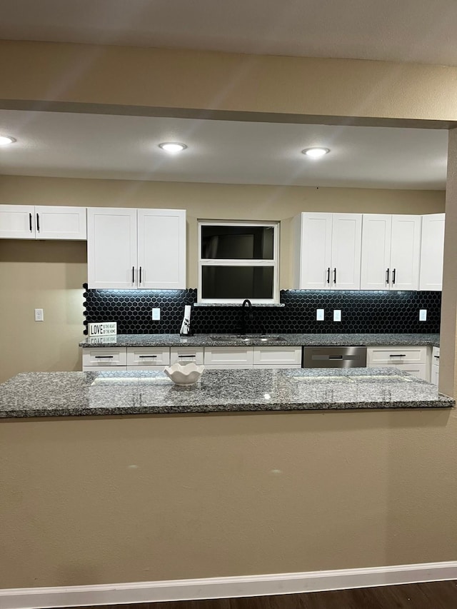 kitchen with white cabinetry, dark stone counters, and sink