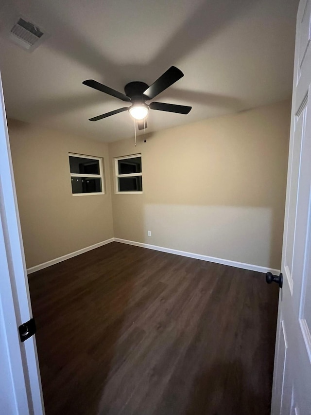 spare room with ceiling fan and dark hardwood / wood-style flooring