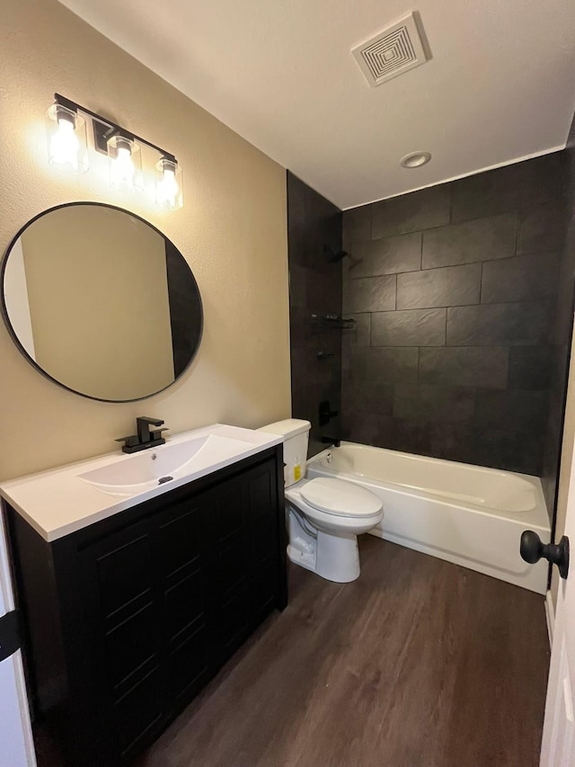 full bathroom with toilet, vanity, tiled shower / bath combo, and hardwood / wood-style flooring