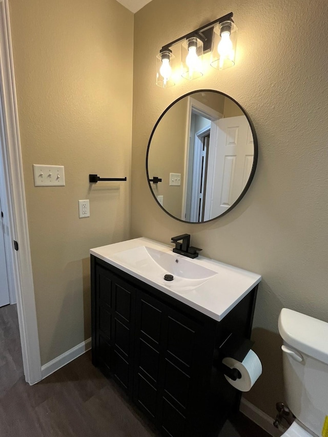 bathroom featuring vanity, hardwood / wood-style flooring, and toilet