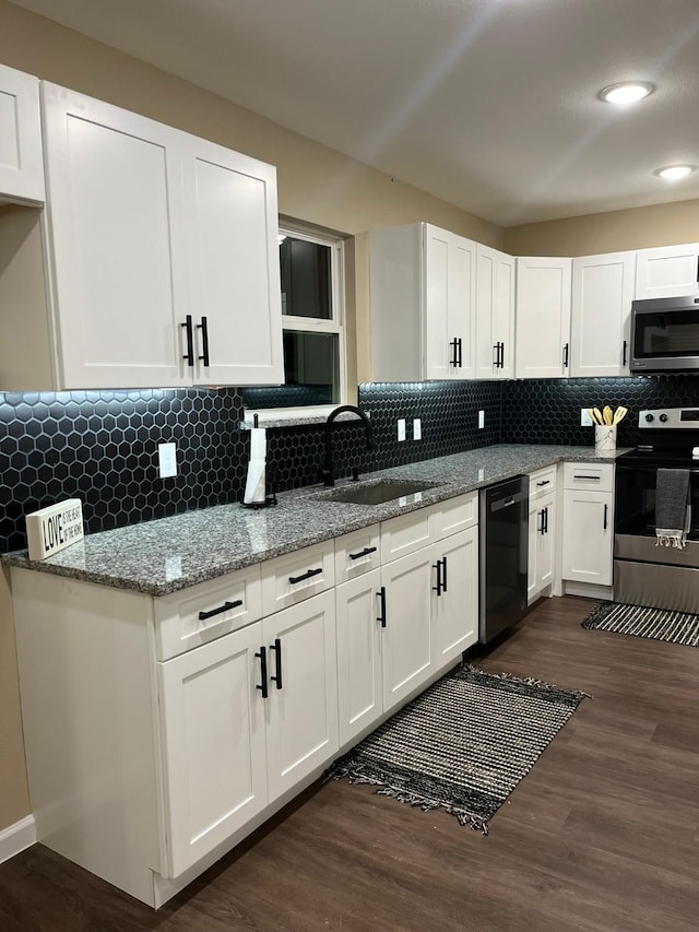 kitchen featuring appliances with stainless steel finishes, light stone counters, sink, white cabinets, and dark hardwood / wood-style floors