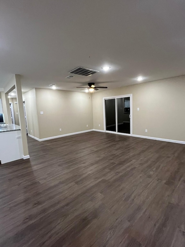 unfurnished living room with dark hardwood / wood-style flooring and ceiling fan