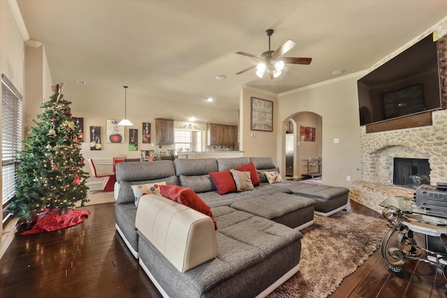 living room featuring a fireplace, ornamental molding, dark hardwood / wood-style floors, and ceiling fan