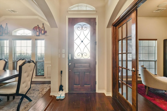 entrance foyer with crown molding and dark wood-type flooring