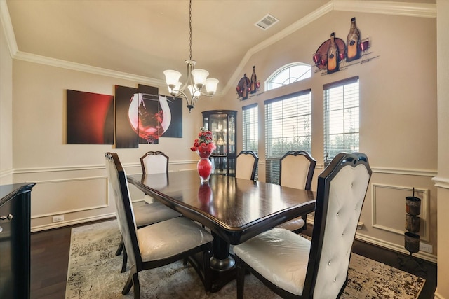 dining space with vaulted ceiling, wood-type flooring, ornamental molding, and a notable chandelier