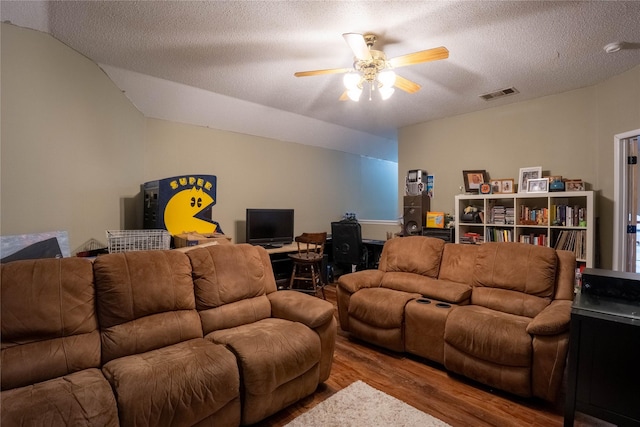 living room with ceiling fan, wood-type flooring, and a textured ceiling