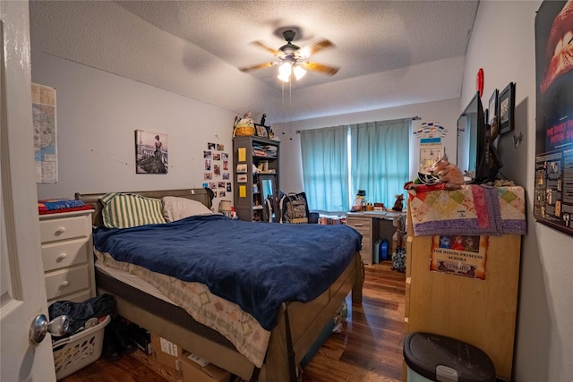 bedroom with ceiling fan, dark hardwood / wood-style flooring, and a textured ceiling