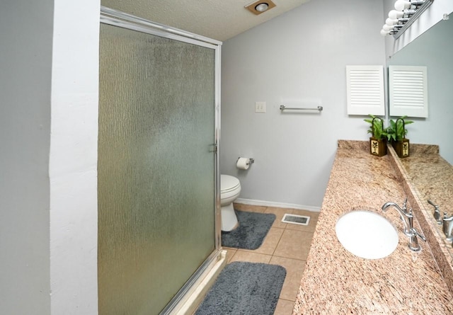 bathroom featuring tile patterned floors, vanity, a textured ceiling, toilet, and a shower with shower door