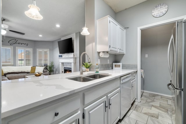 kitchen with stainless steel refrigerator, dishwasher, sink, pendant lighting, and white cabinets