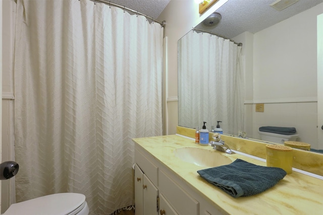 bathroom with vanity, a textured ceiling, and toilet