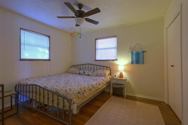 bedroom featuring hardwood / wood-style flooring, a textured ceiling, and ceiling fan