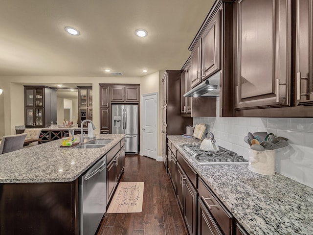 kitchen featuring sink, dark hardwood / wood-style flooring, stainless steel appliances, dark brown cabinets, and a center island with sink