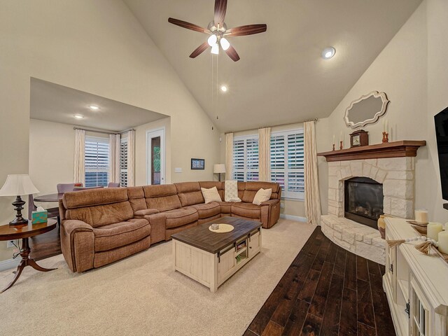 living room with ceiling fan and a fireplace