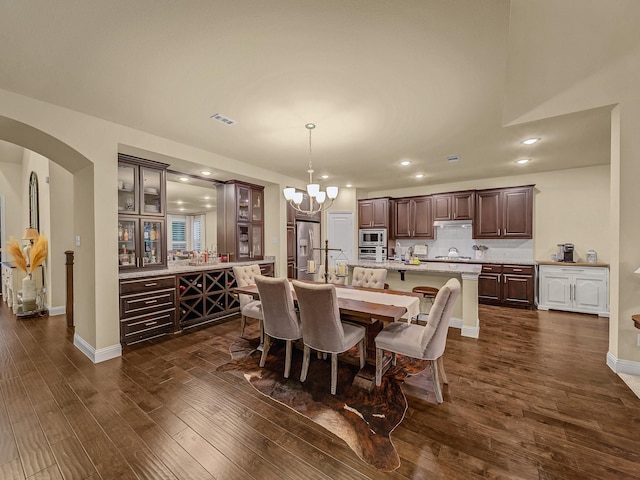 dining room with dark hardwood / wood-style floors and a chandelier