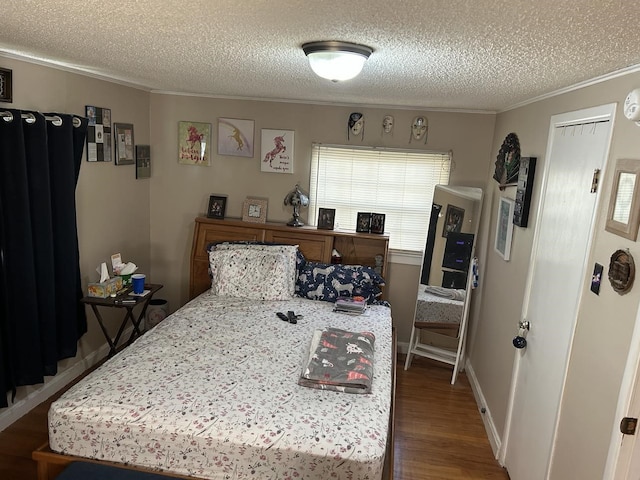 bedroom with crown molding, a textured ceiling, and dark wood-type flooring