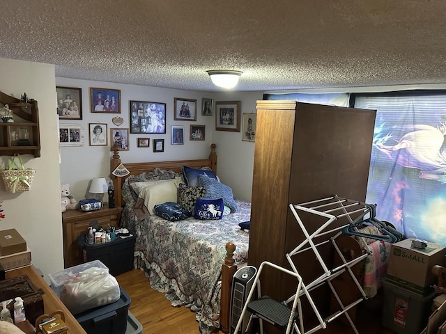 bedroom with wood-type flooring and a textured ceiling