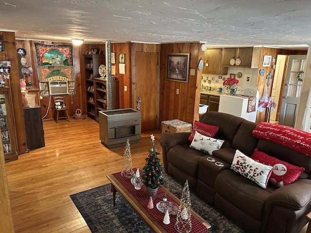 living room featuring light hardwood / wood-style floors, washer / clothes dryer, and wooden walls