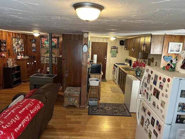 living room with wood walls, washer / dryer, and light hardwood / wood-style floors