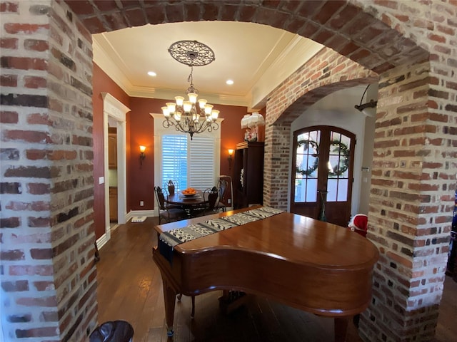 dining area featuring french doors, brick wall, crown molding, and dark hardwood / wood-style flooring