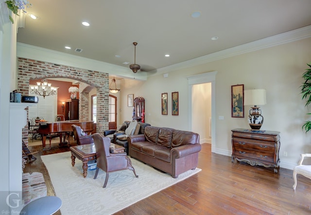 living room with ornamental molding, hardwood / wood-style floors, and a notable chandelier