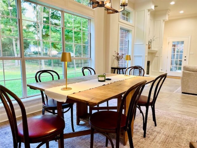 dining space with ornamental molding and light hardwood / wood-style flooring