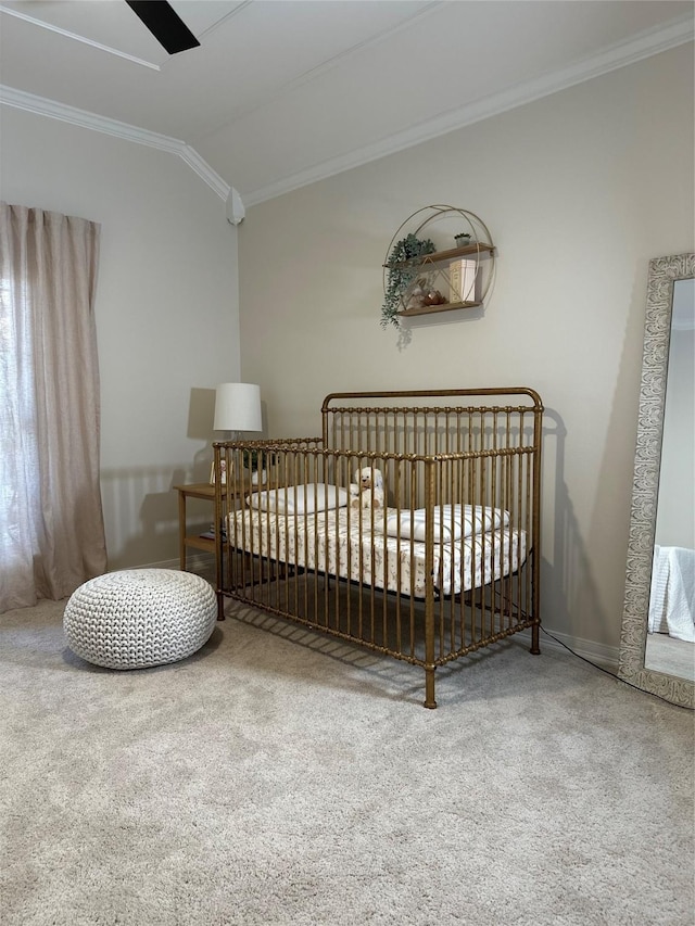 carpeted bedroom with a crib, ornamental molding, ceiling fan, and lofted ceiling