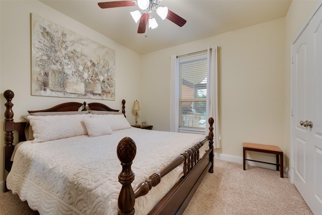 bedroom featuring ceiling fan, a closet, and light colored carpet