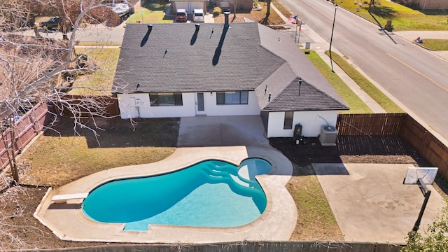 view of swimming pool with a diving board, cooling unit, and a patio area