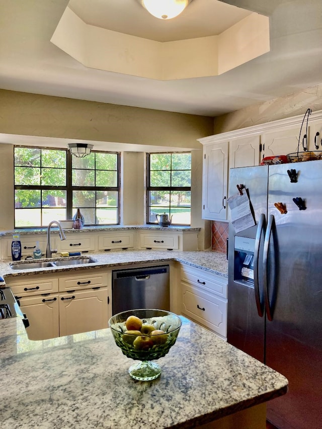 kitchen featuring sink, a tray ceiling, stainless steel appliances, and white cabinets