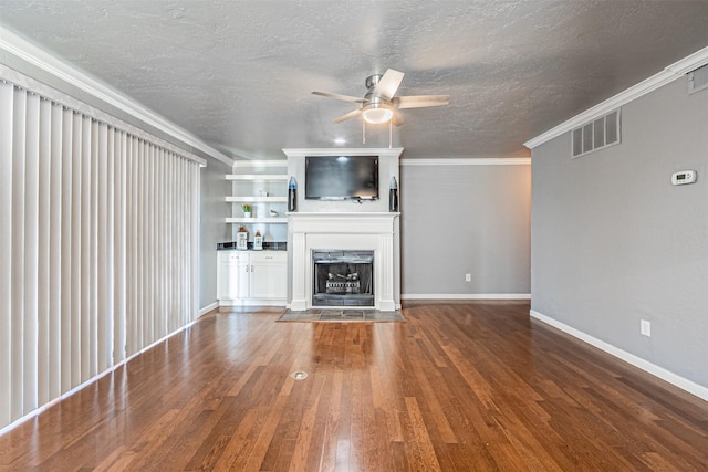 unfurnished living room featuring ornamental molding, built in shelves, a textured ceiling, ceiling fan, and hardwood / wood-style flooring