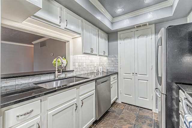 kitchen with stainless steel appliances, a sink, white cabinetry, ornamental molding, and a tray ceiling