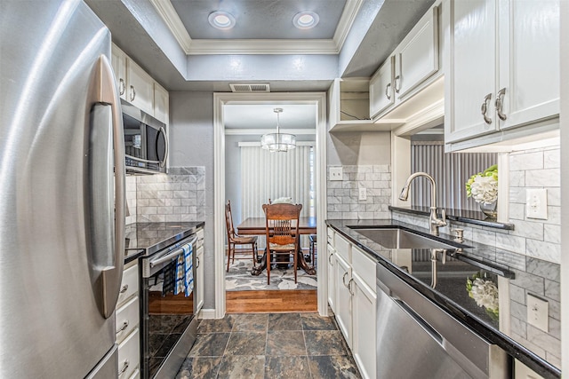 kitchen featuring stainless steel appliances, a sink, white cabinetry, visible vents, and crown molding