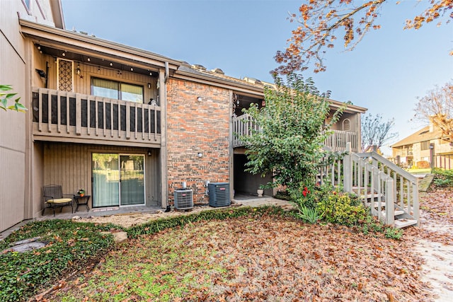 rear view of property featuring brick siding and central air condition unit