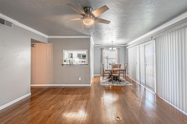 unfurnished dining area with wood-type flooring, ceiling fan with notable chandelier, a textured ceiling, and ornamental molding