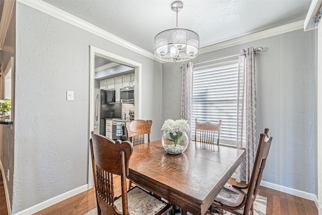 dining room featuring hardwood / wood-style floors, ornamental molding, and a chandelier