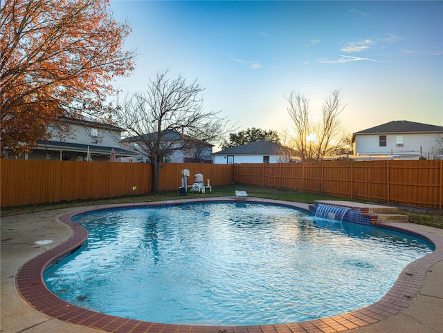 pool at dusk with pool water feature